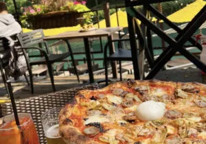 Una pizza artesanal de Robert’s Pizza & Dough Co. con masa fina y crujiente en Chicago, reconocida entre las mejores pizzas de Estados Unidos.