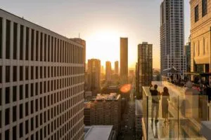 Personas disfrutando cocteles en azoteas Chicago con vistas al skyline y lago Michigan al atardecer
