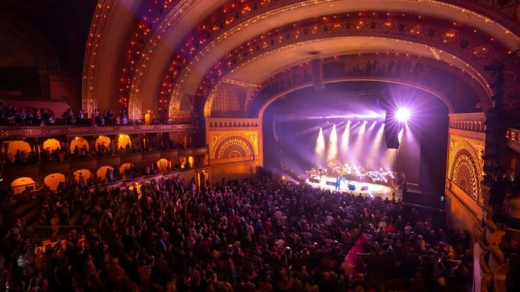 Escenario de conciertos en Chicago abril con luces, público y artistas en vivo en un show multitudinario
