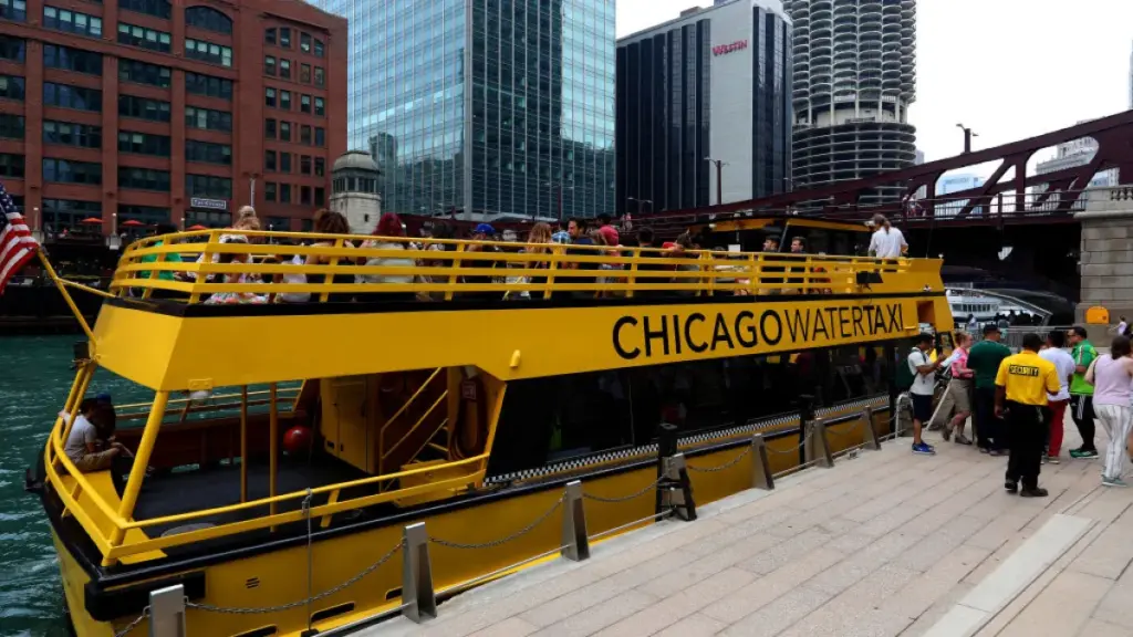 Chicago Water Taxi navegando por el río Chicago con rascacielos del centro reflejados en el agua durante un día soleado
