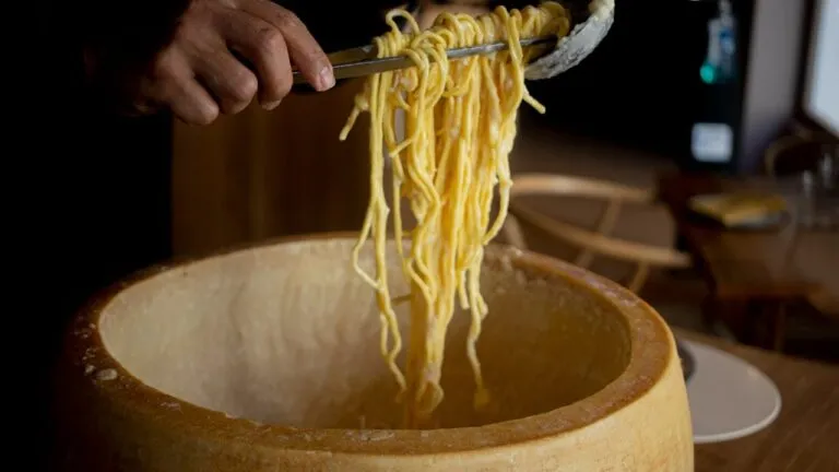 pasta en queso parmesano preparada en rueda de queso en restaurante elegante de Chicago con presentación gourmet