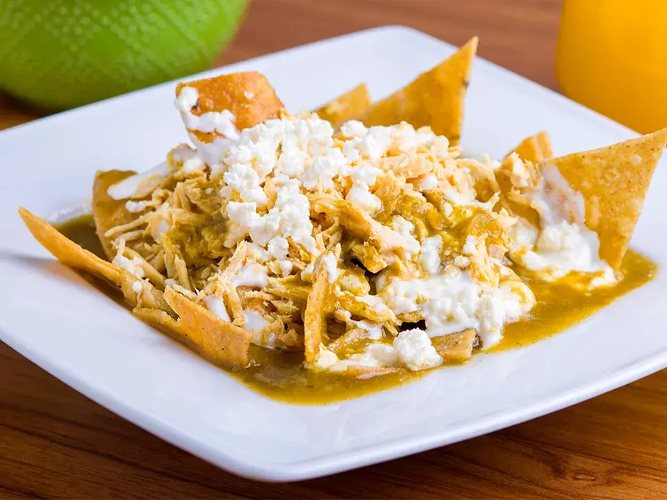 chilaquiles verdes Chicago en brunch con salsa verde, queso y huevo en restaurante mexicano moderno