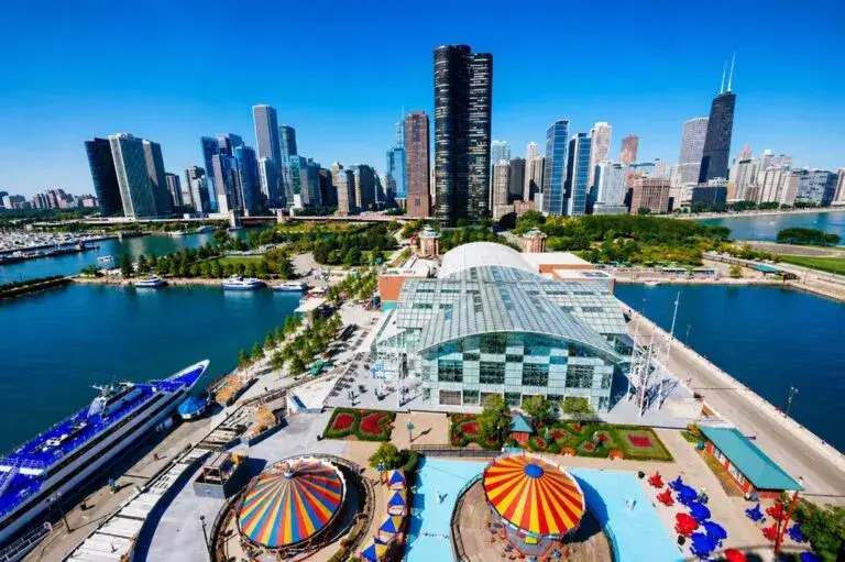 Navy Pier Chicago con visitantes, rueda de la fortuna y actividad turística en zona urbana moderna