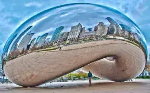 Cloud Gate Chicago reflejando edificios y turistas en Millennium Park
