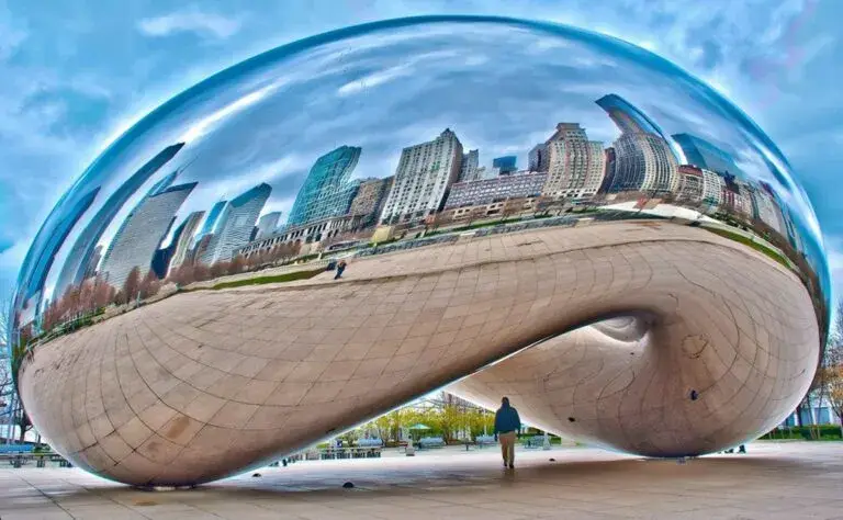 Cloud Gate Chicago reflejando edificios y turistas en Millennium Park