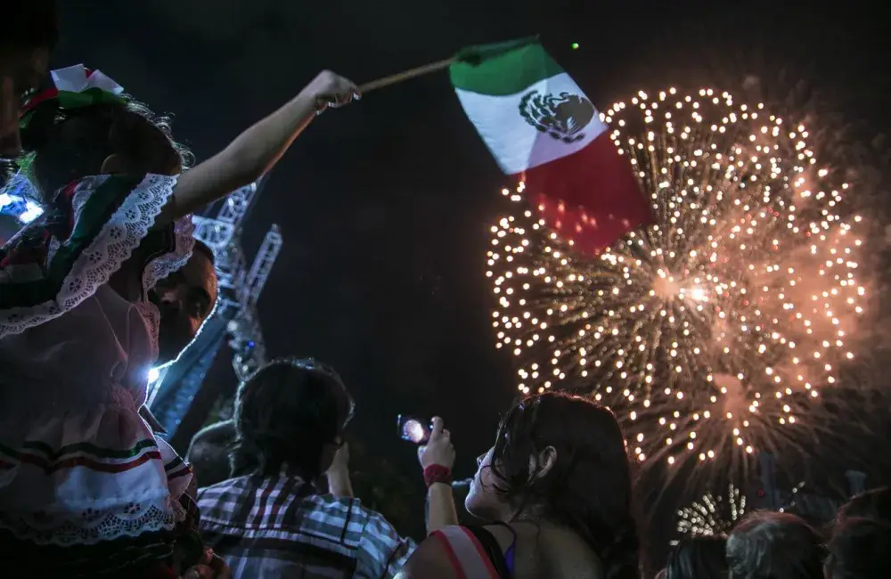 Celebración de la Independencia de México en Chicago con banderas mexicanas y participantes en La Villita.