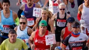 Persona utilizando un teléfono celular para consultar el avance de los corredores durante el Maratón de Chicago 2026.