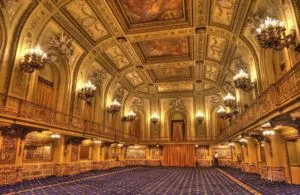 Fachada nocturna del Congress Plaza Hotel con su característico letrero rojo y una atmósfera misteriosa.